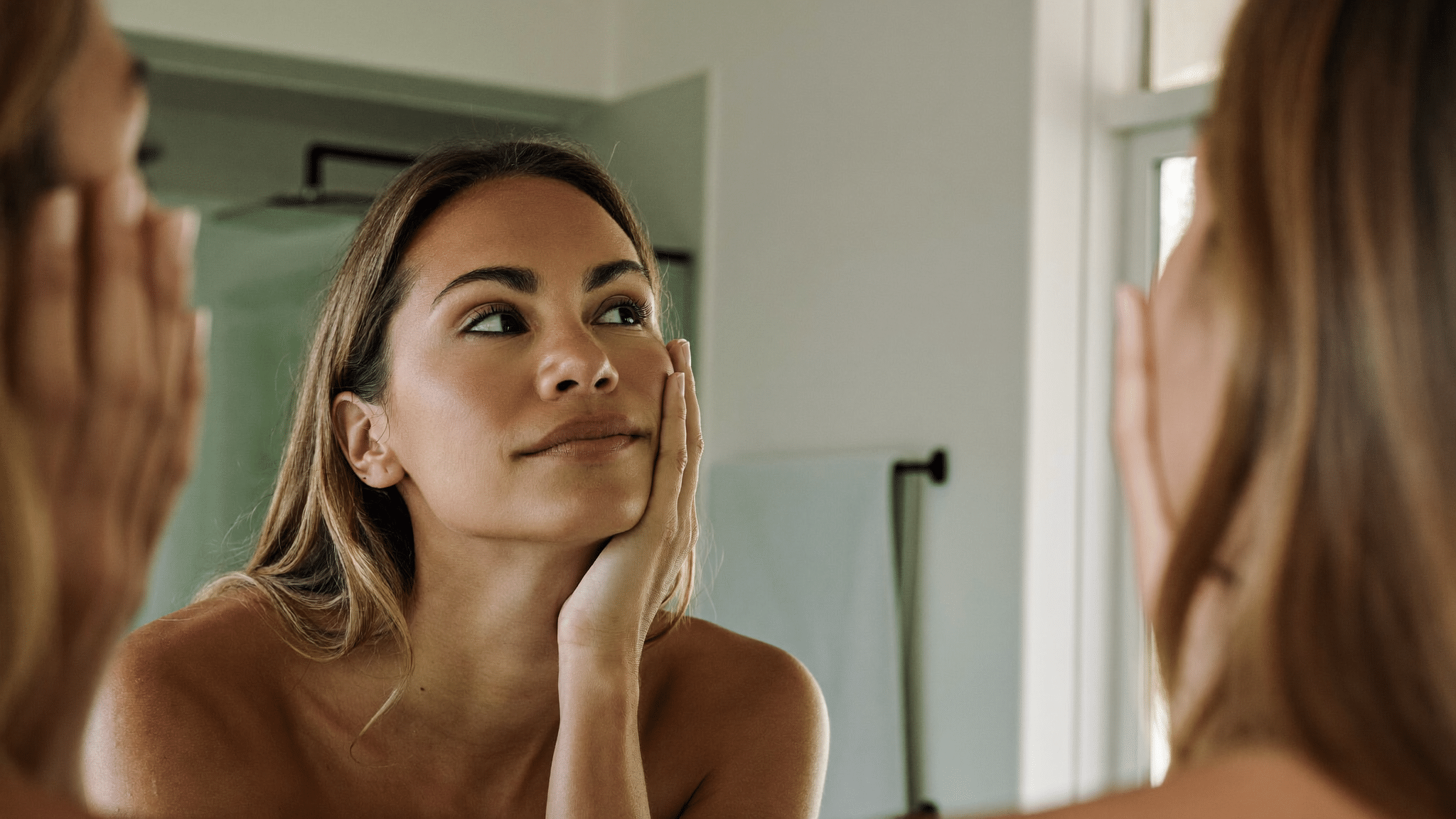 Woman looking at her nose profile in a mirror — assessing supratip fullness and polly beak deformity after rhinoplasty, Centre for Surgery London