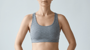 Woman in a fitted sports bra showing the armpit and side chest area where armpit fat and accessory breast tissue appear — Centre for Surgery London