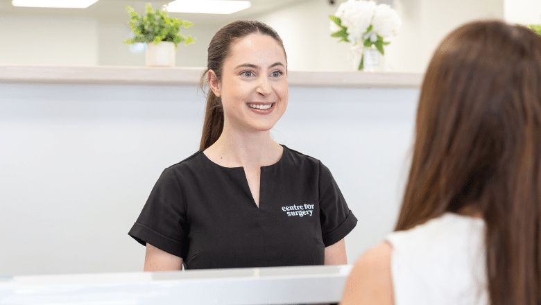 A Centre for Surgery patient coordinator speaking with a patient at reception in the Baker Street clinic, London