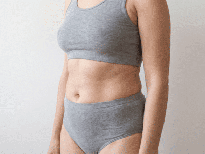 Illustrative photograph showing a B belly shape in three-quarter view, with a horizontal crease across the midline dividing the upper and lower abdomen into two curves