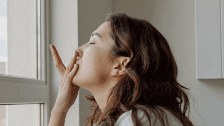 Woman in profile easing the side of her nose to breathe more freely — nasal valve collapse assessment and treatment, Centre for Surgery London